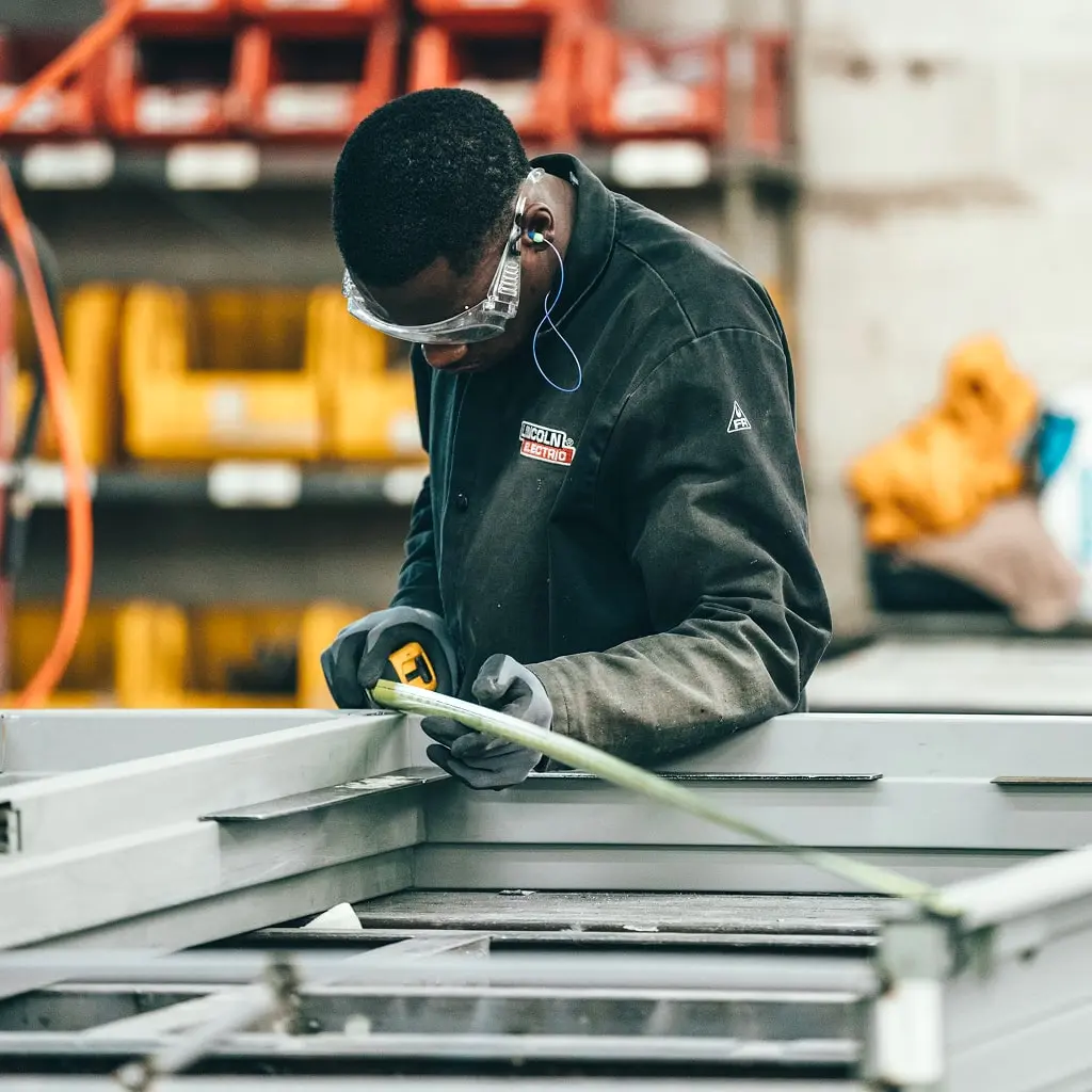 A man measuring square metal tube