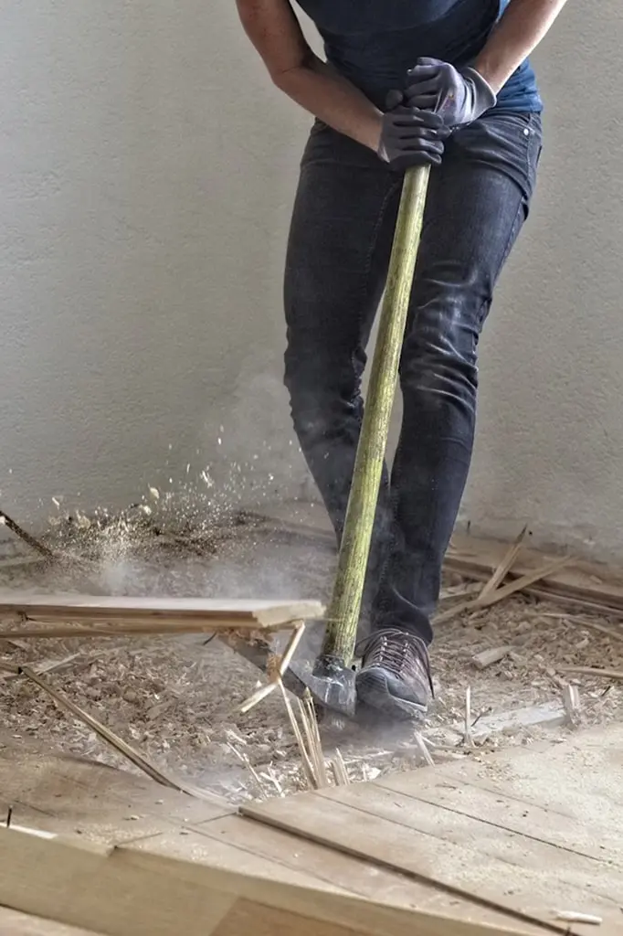 A man breaking up a wood floor